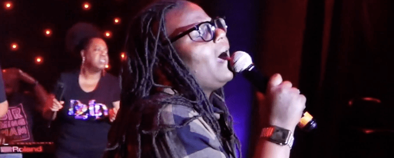 Singer performing on stage with microphone.